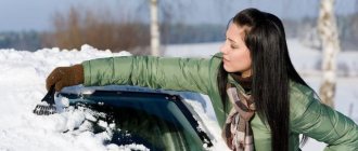Женщина убирает снег с машины